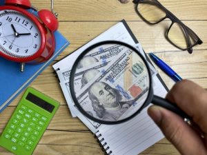 Magnifying glass searching for hidden retirement costs and money