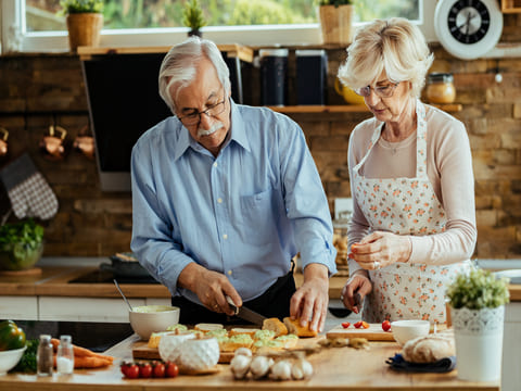 Healthy senior couple cooking together in the kitchen