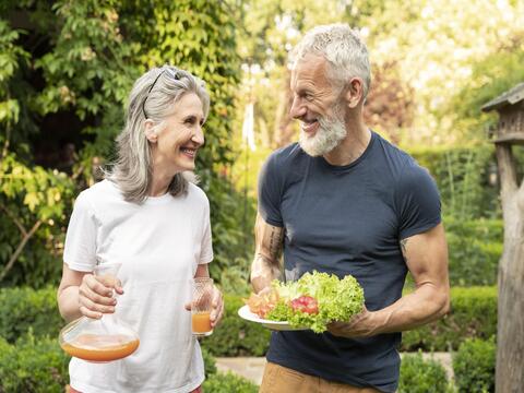 smiling older couple enjoying nature while exercising, staying healthy after 60