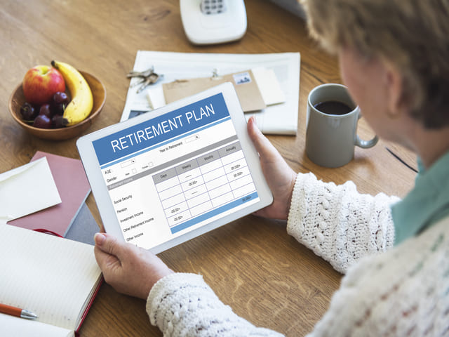Woman holding an iPad showing a retirement budget